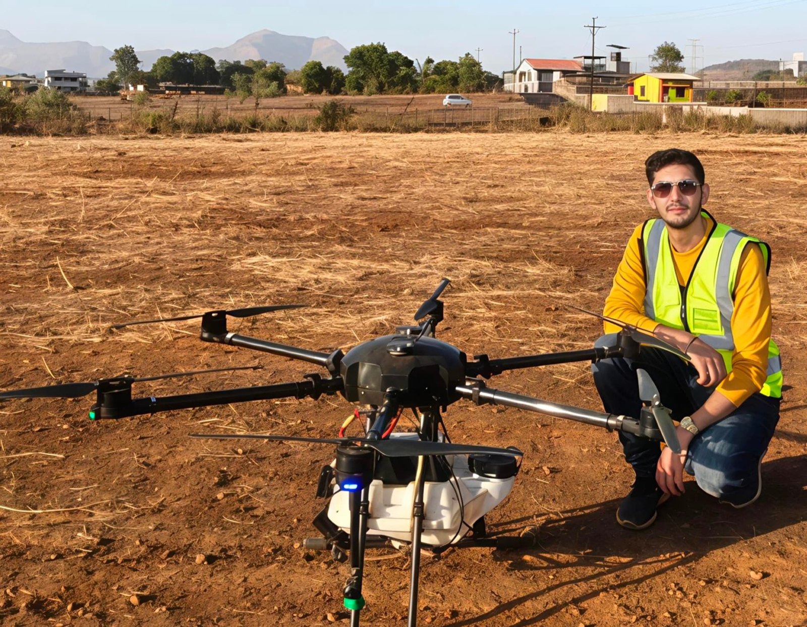 Vinay Dambani beside a large training drone on an open outdoor training field
